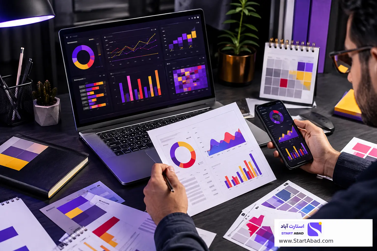 لپ‌تاپ و موبایل روی میز کار برای پایش بودجه و عملکرد کمپین تبلیغاتی